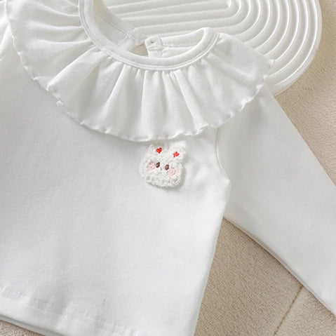 White long-sleeve top with ruffled doll collar and bunny patch