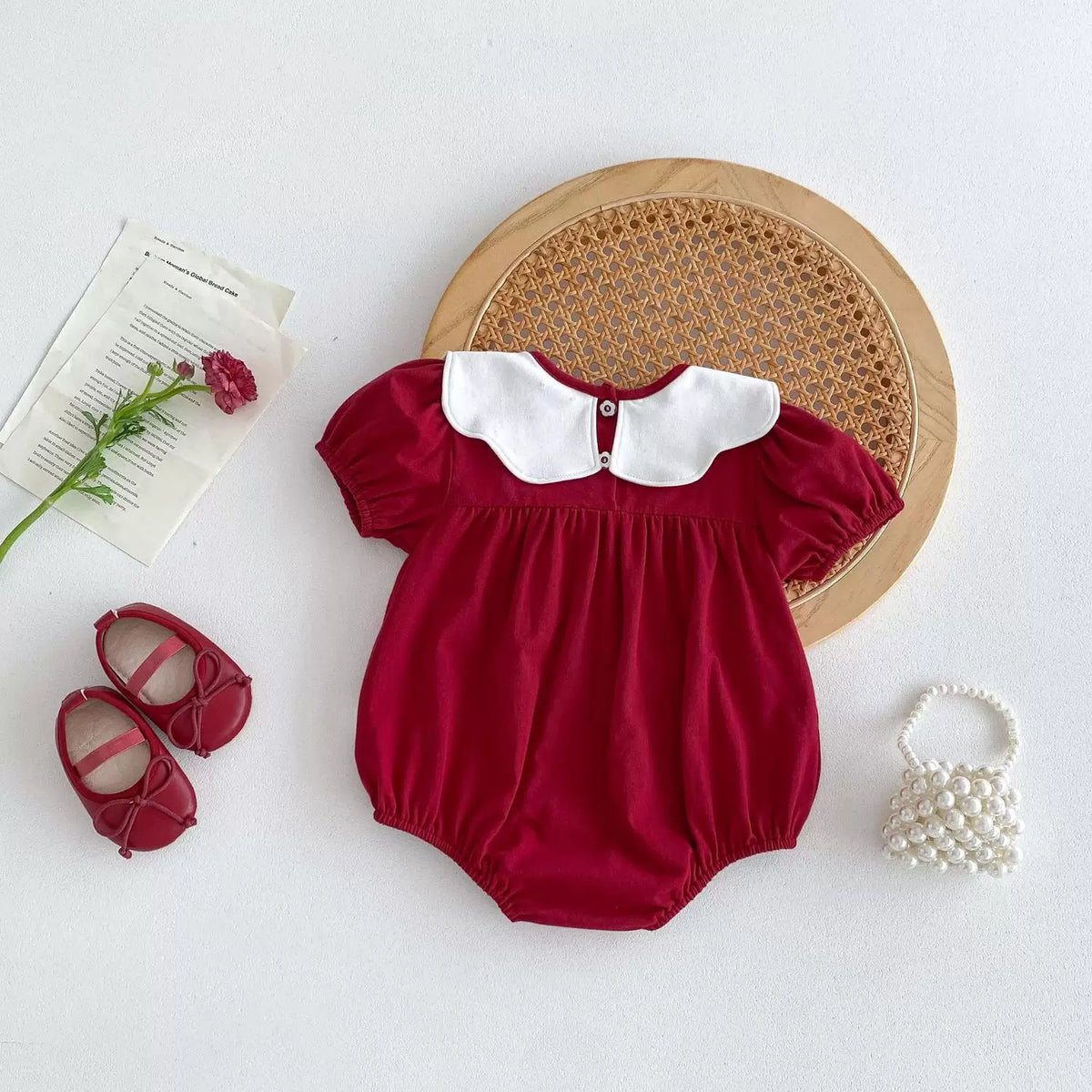 Back view of the red bodysuit showing the collar button
