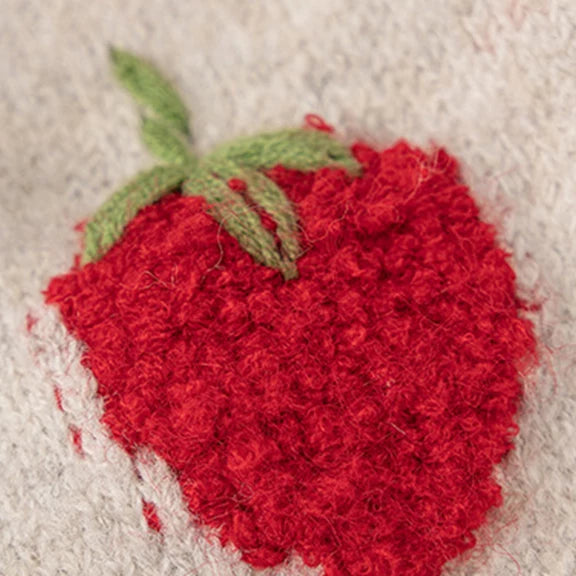 Close-up of bobbly red strawberry knit with green leaves