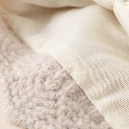 Close-up of the soft inner lining and scalloped edge of the knit bonnet
