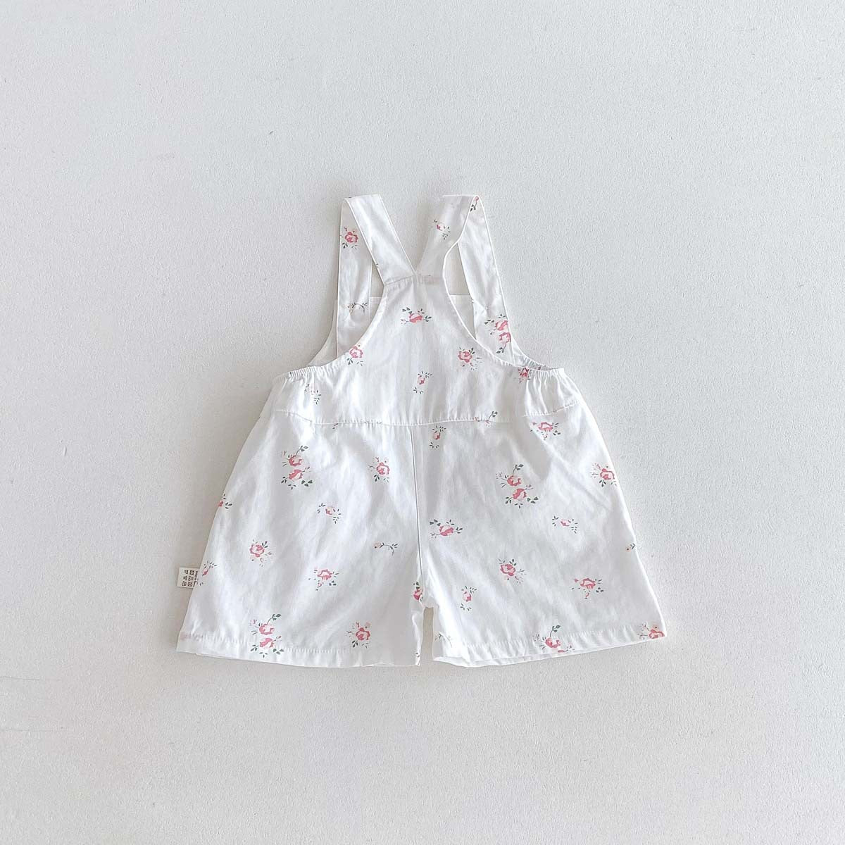 White rosebud print baby overalls back view, cotton romper shorts