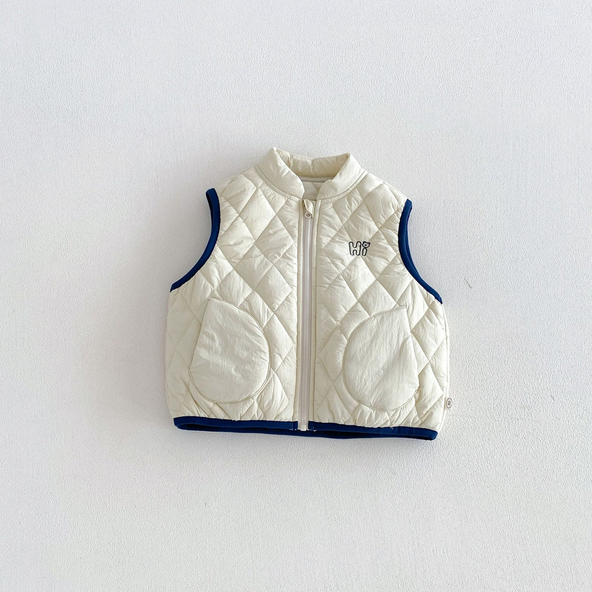 Ivory quilted puffer vest with navy trim, front view