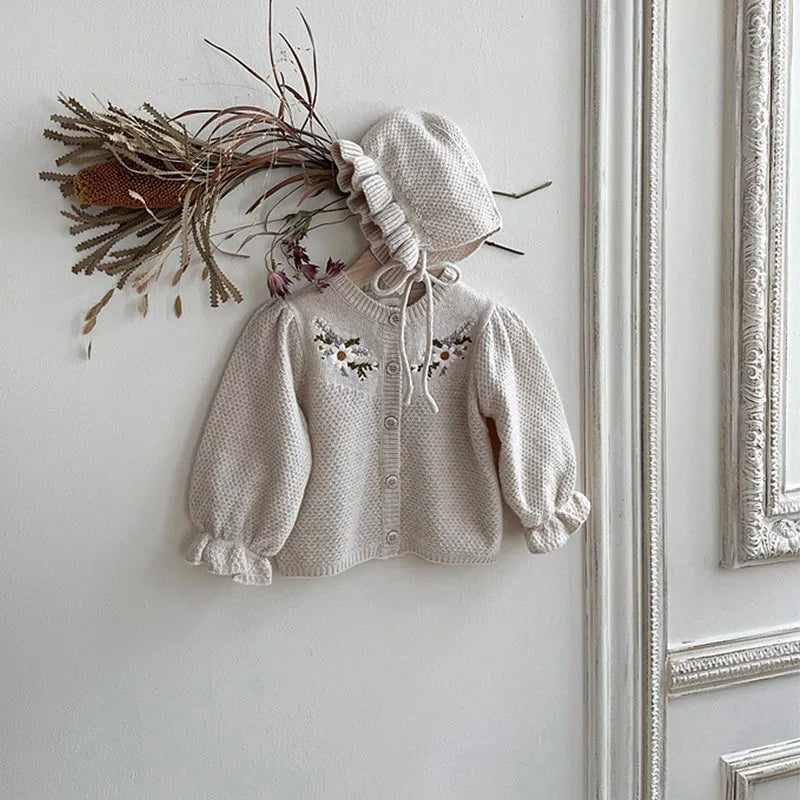 Apricot floral cardigan hanging with bonnet