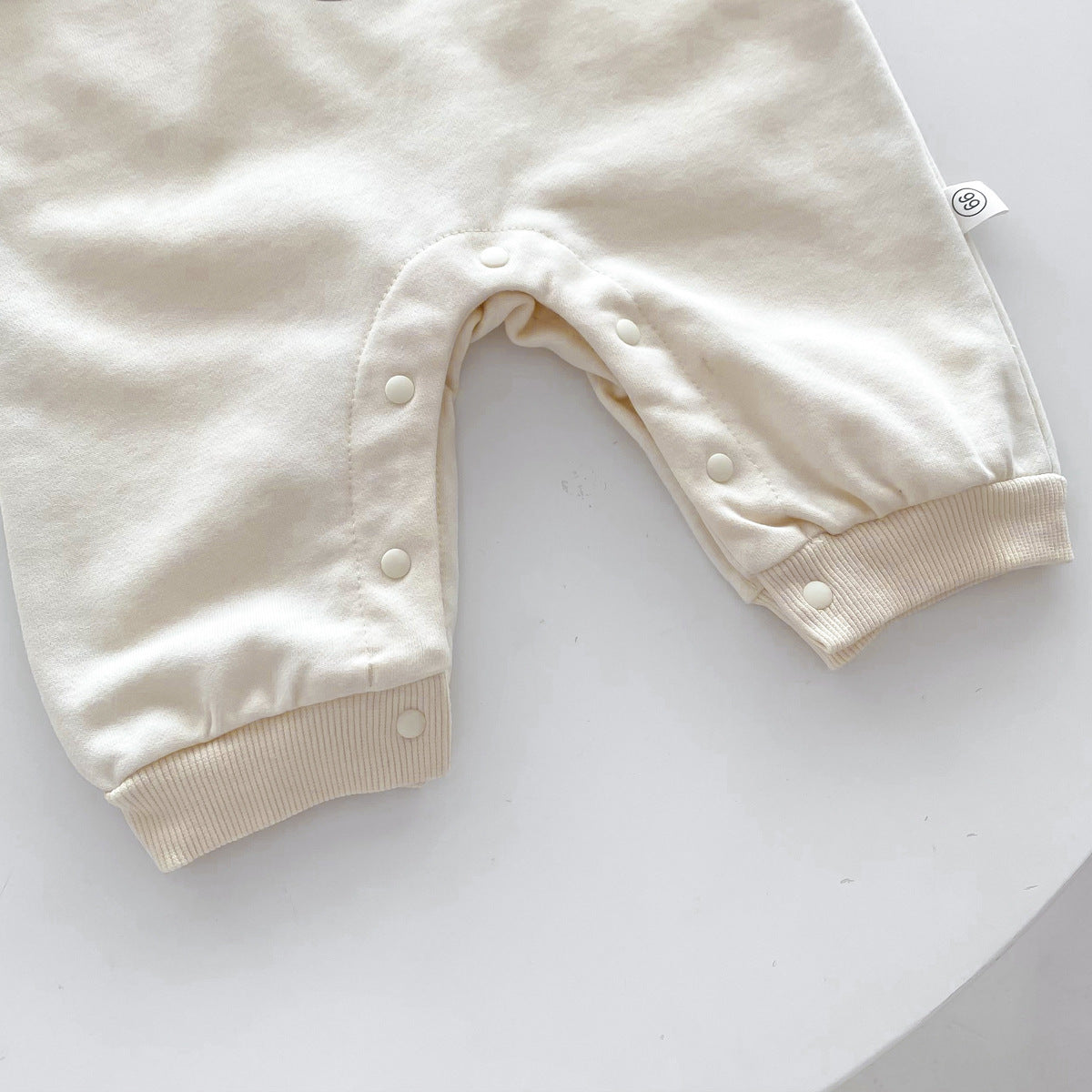 Close-up of legs on apricot bear jumpsuit