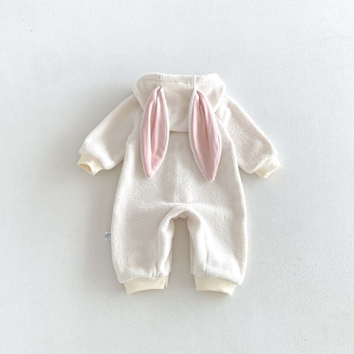 Back of the ivory bunny romper with pink floppy ears