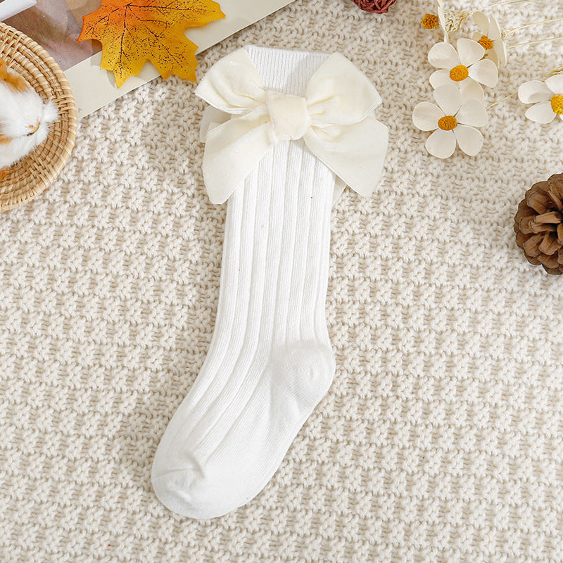 White ribbed knee-high baby socks with bow