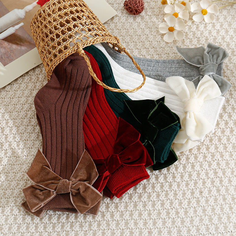 Ribbed velvet bow baby socks in a basket
