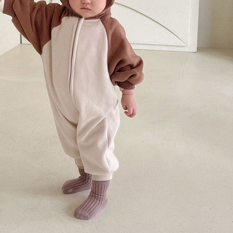 Baby wearing brown and cream hooded jumpsuit