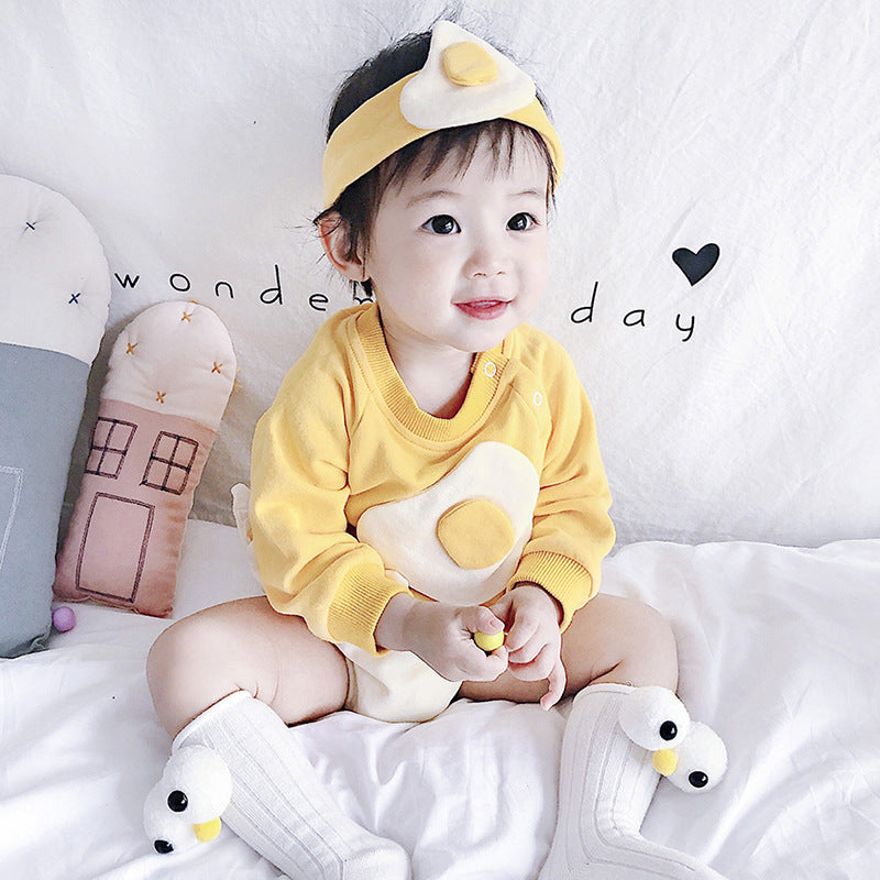 Baby wearing yellow fried egg romper and headband