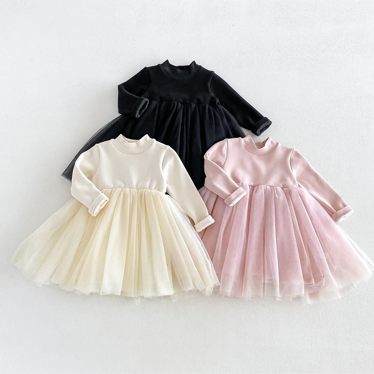 Black, cream and blush tulle dresses laid out together