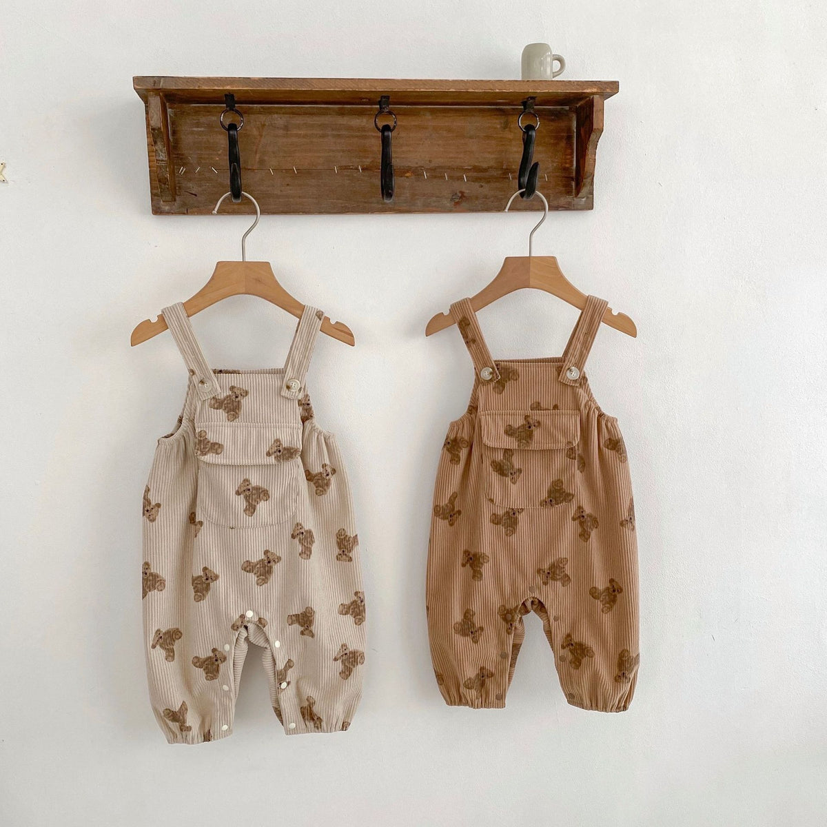 Beige and brown bear print sleeveless baby overalls on hangers