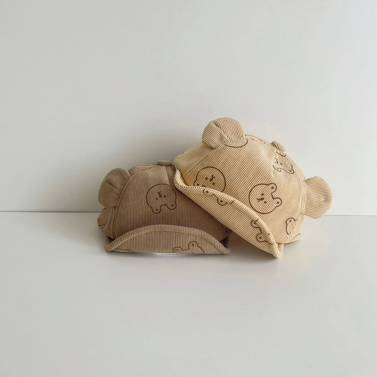 Bear print corduroy baby caps side by side