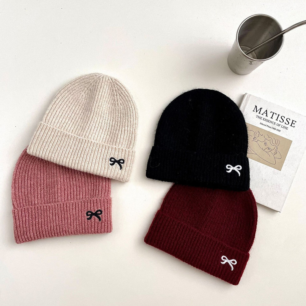 Beige, black, red and pink knit beanies with bows