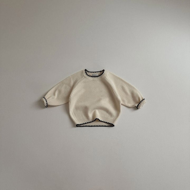 Beige knit sweater with black contrast trim