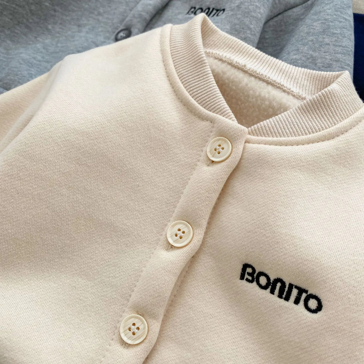 Close-up of buttons and embroidery on beige jacket