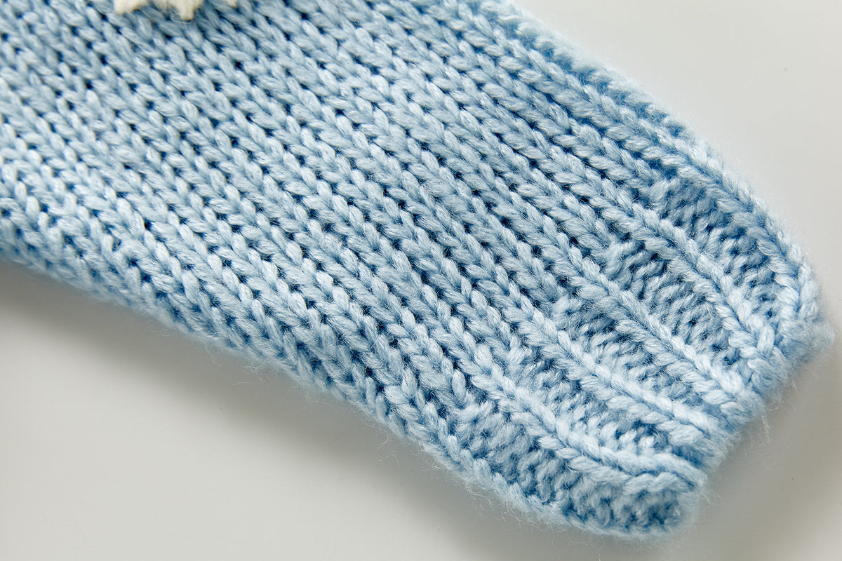 Close-up of ribbed cuff on blue knit cardigan
