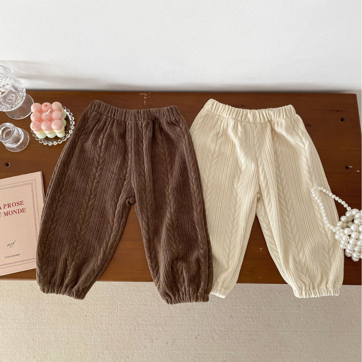 Brown and beige baby trousers laid flat