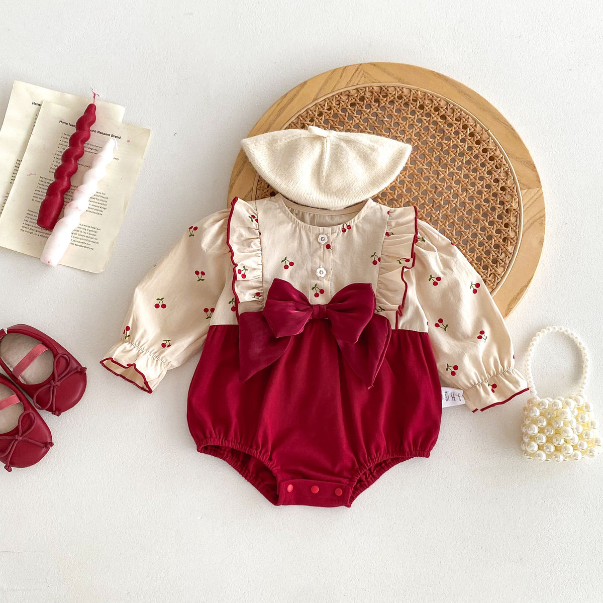 Cherry print Christmas romper with hat and accessories laid flat