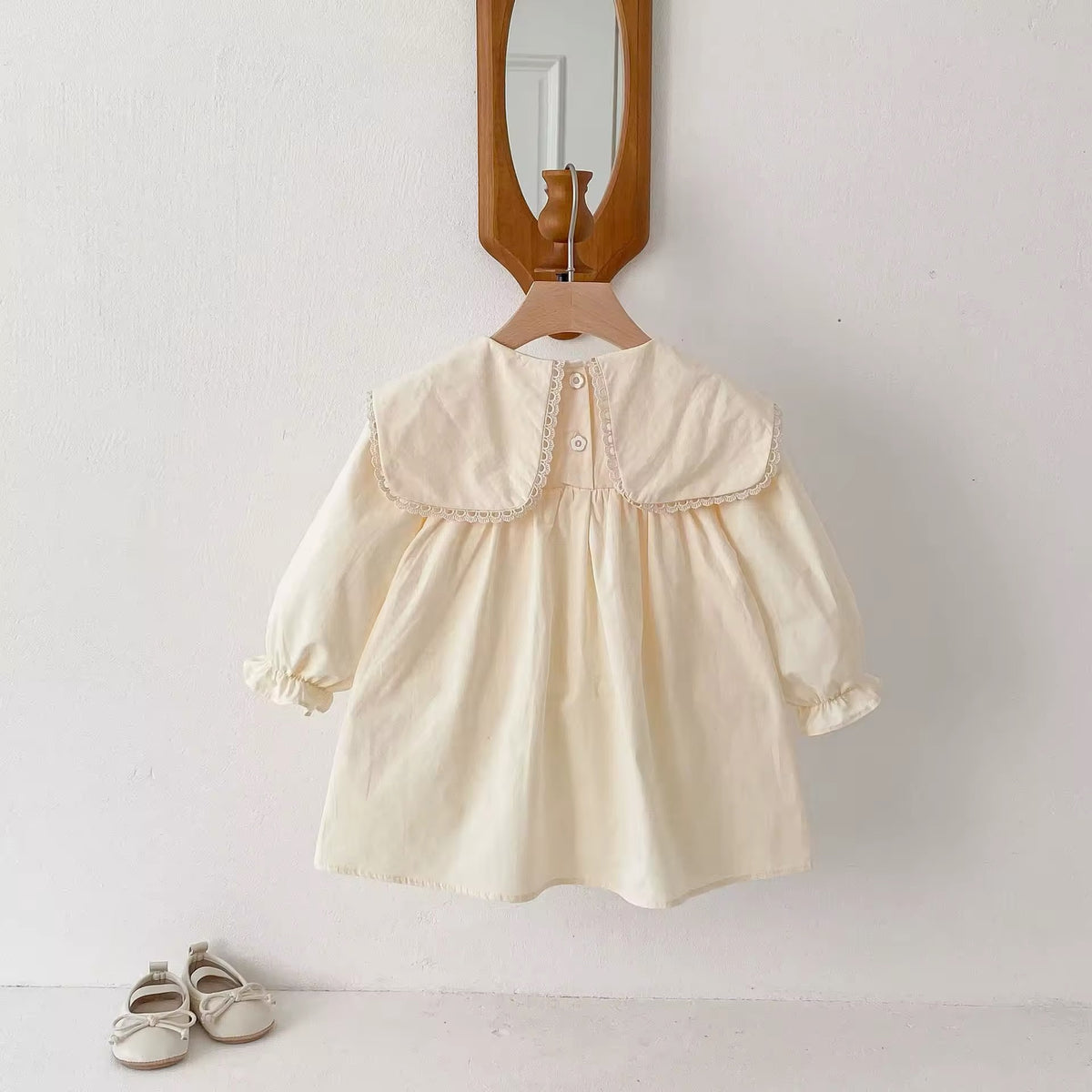 Back view of cream sailor collar dress on a hanger