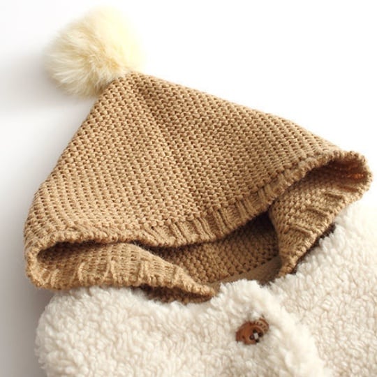 Close-up of the chunky knit hood with a fluffy pom-pom