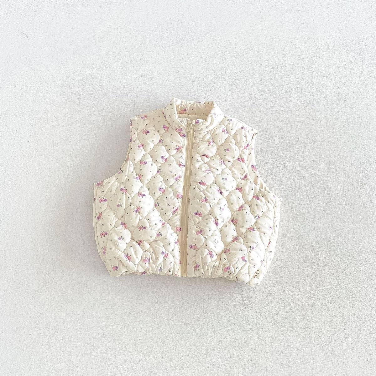Cream floral quilted puffer vest for kids, flat lay