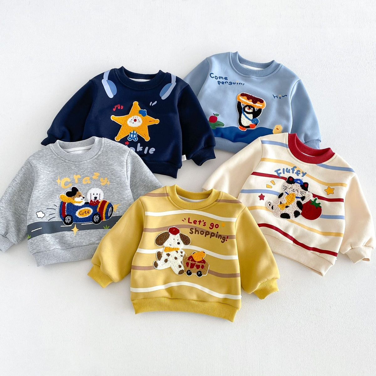 Colourful embroidered toddler sweatshirts laid out together