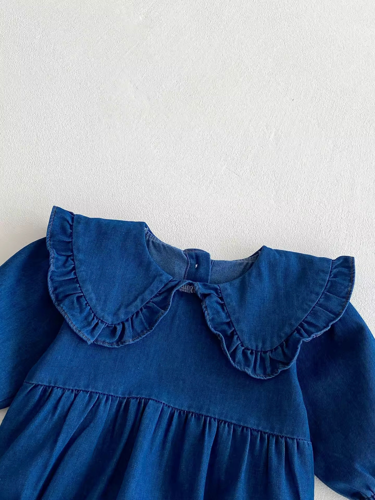 Close-up of frilled collar on denim baby dress