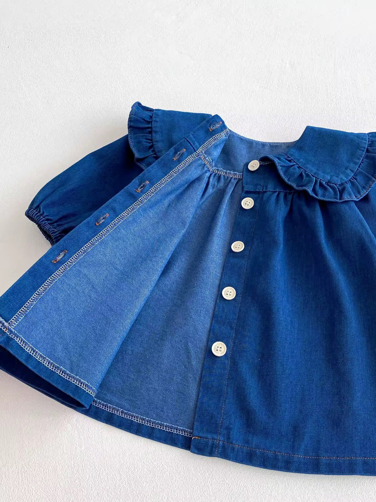 Denim dress opened to show the inside fabric