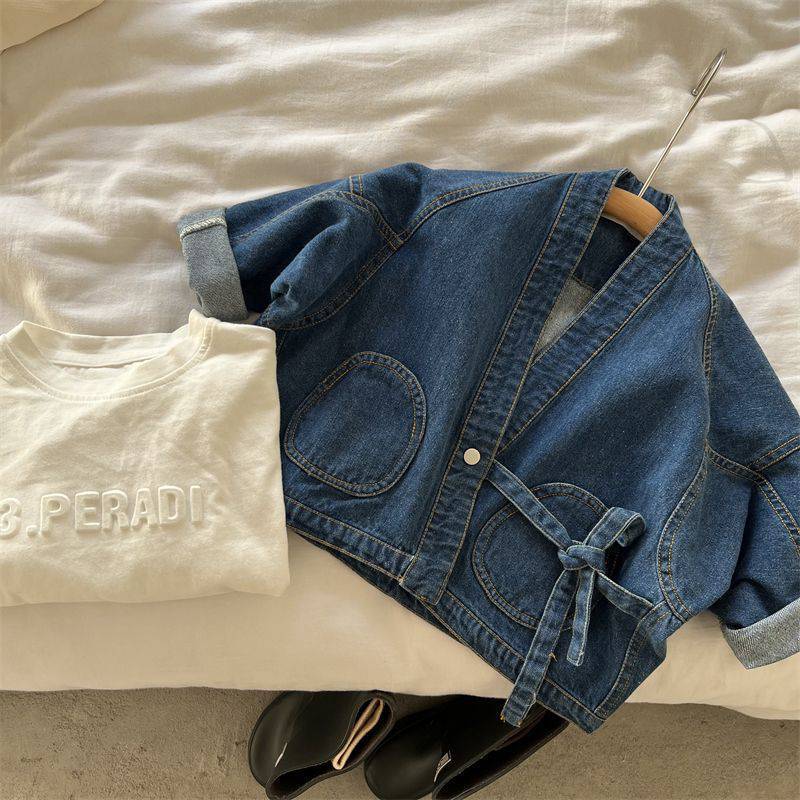 Blue denim wrap jacket with tie laid flat