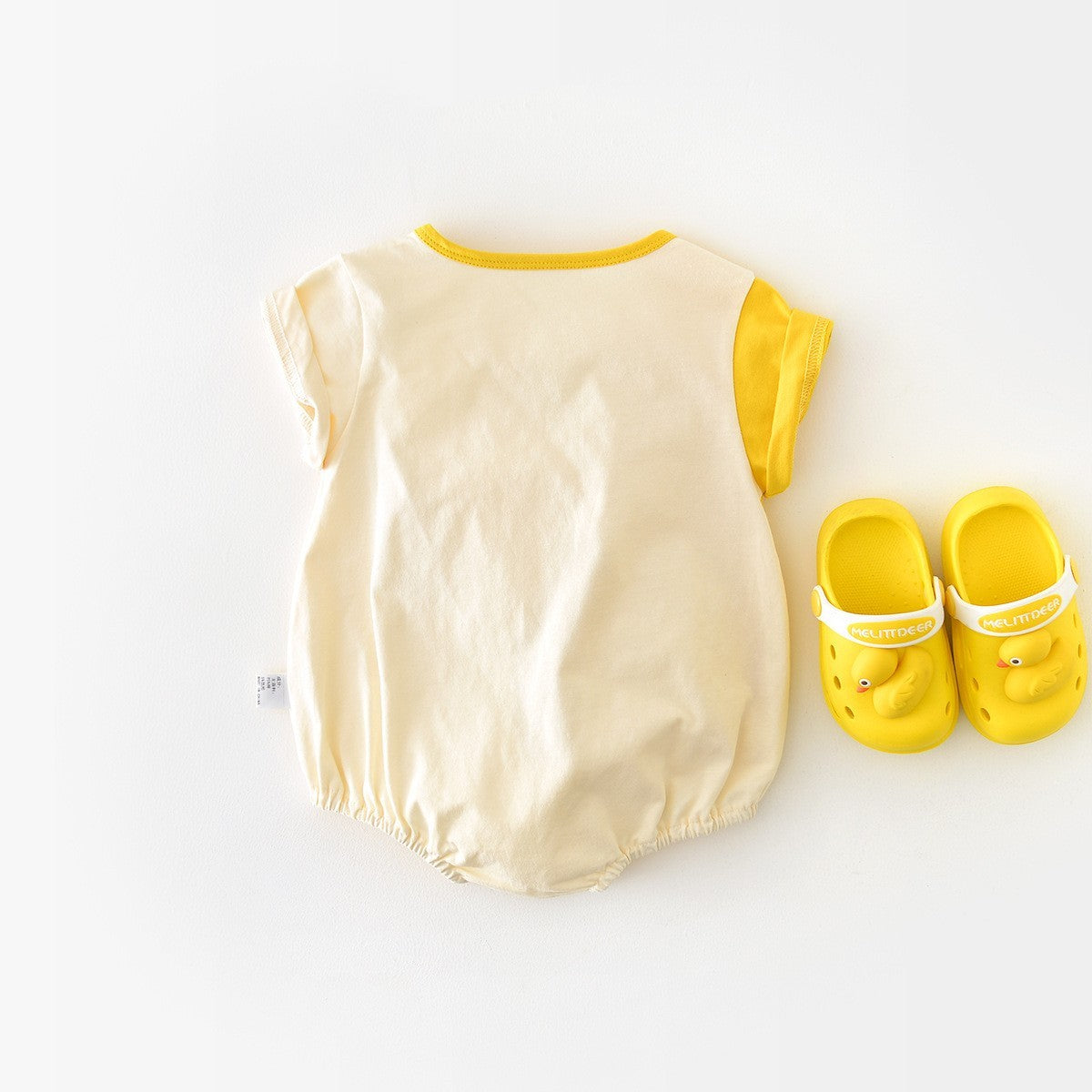 Back view of duck romper with yellow slippers