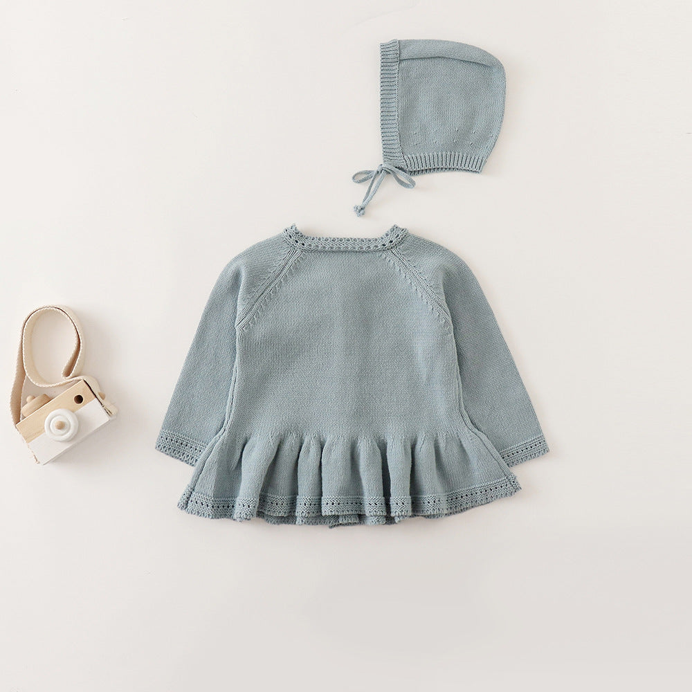 Back view of dusty blue knit baby cardigan with ruffle peplum hem and bonnet