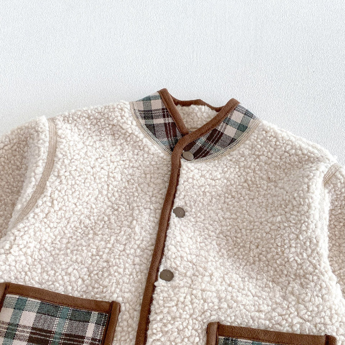 Close-up of the fluffy cream sherpa and plaid collar