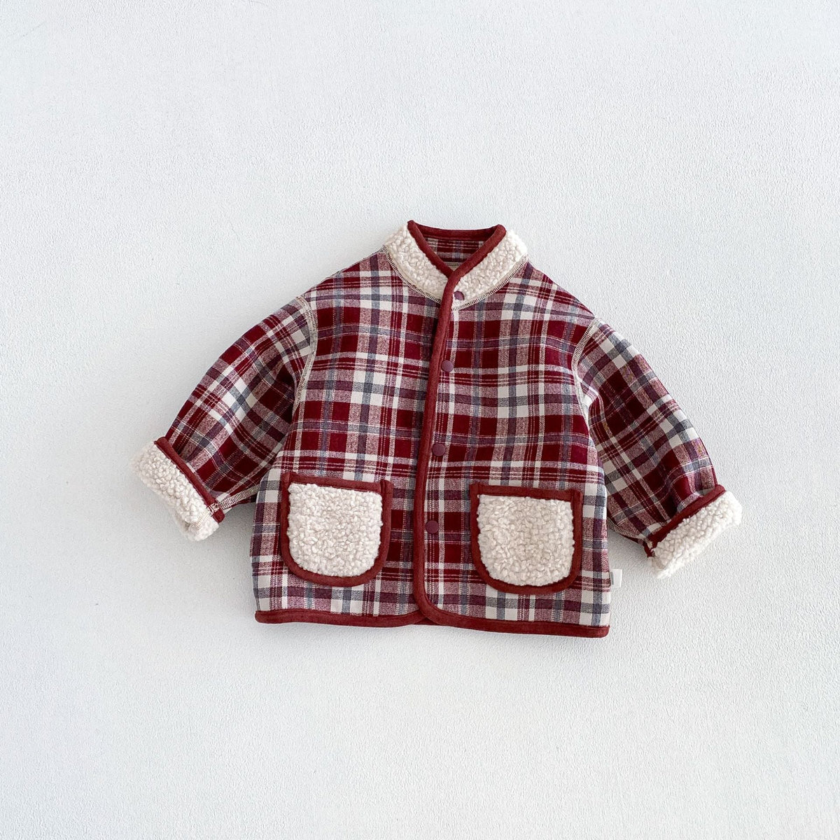 Berry plaid side of the reversible toddler jacket with sherpa pockets