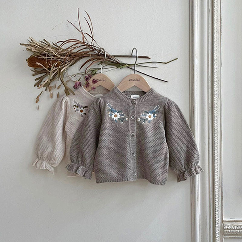 Apricot and grey floral knit cardigans hanging