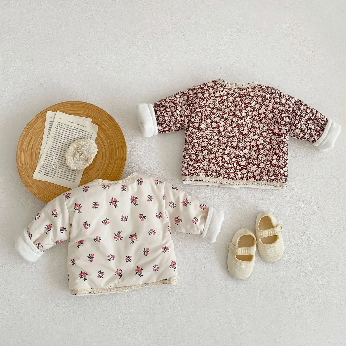 Floral baby jackets laid flat with shoes