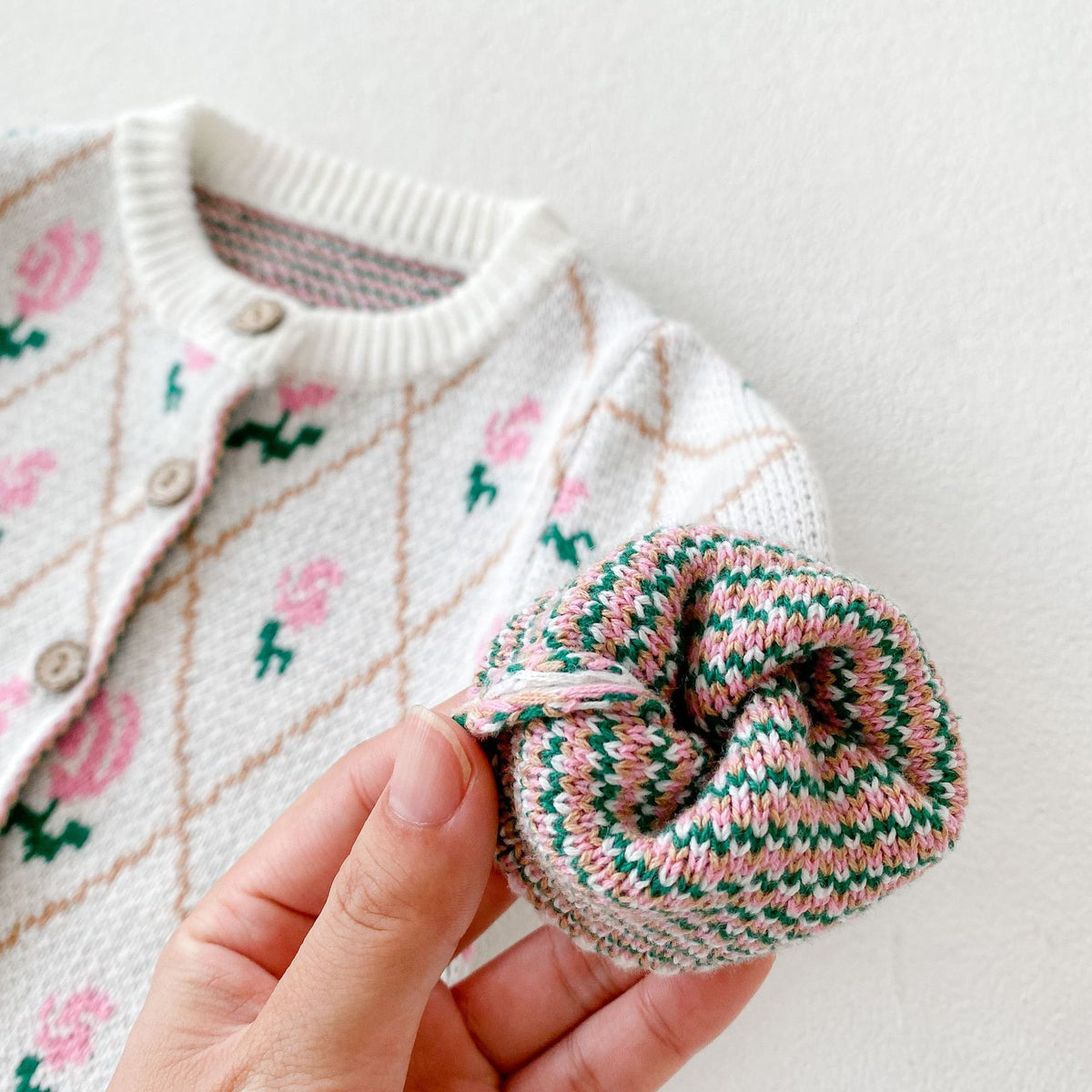 Close-up of striped knit cuff on floral jacquard baby cardigan