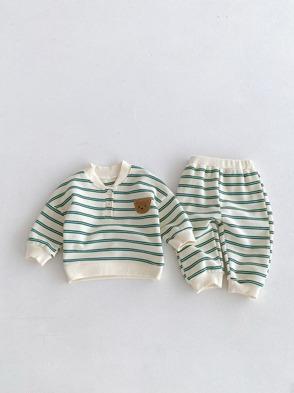 Green striped sweatshirt and pants laid flat