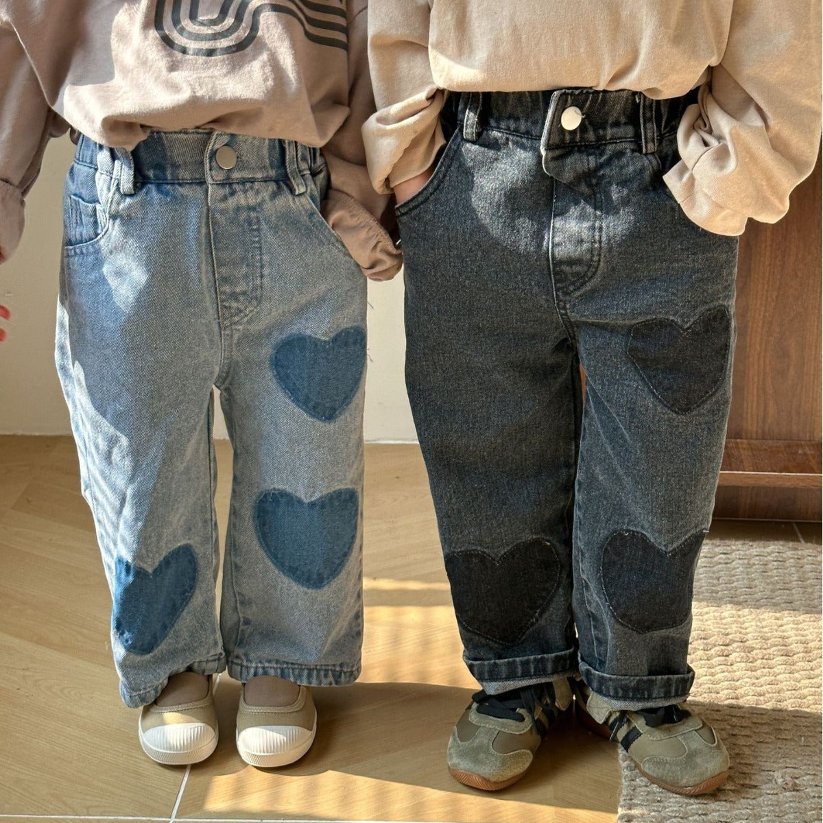 Two kids wearing blue and black heart patch straight jeans
