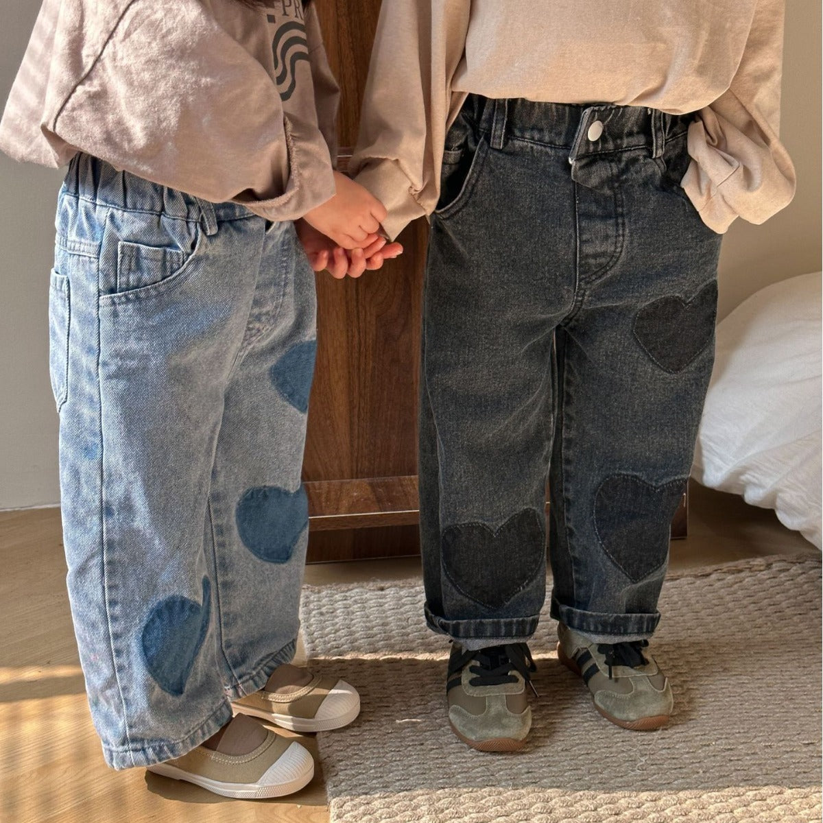 Kids in blue and black heart patch jeans standing together