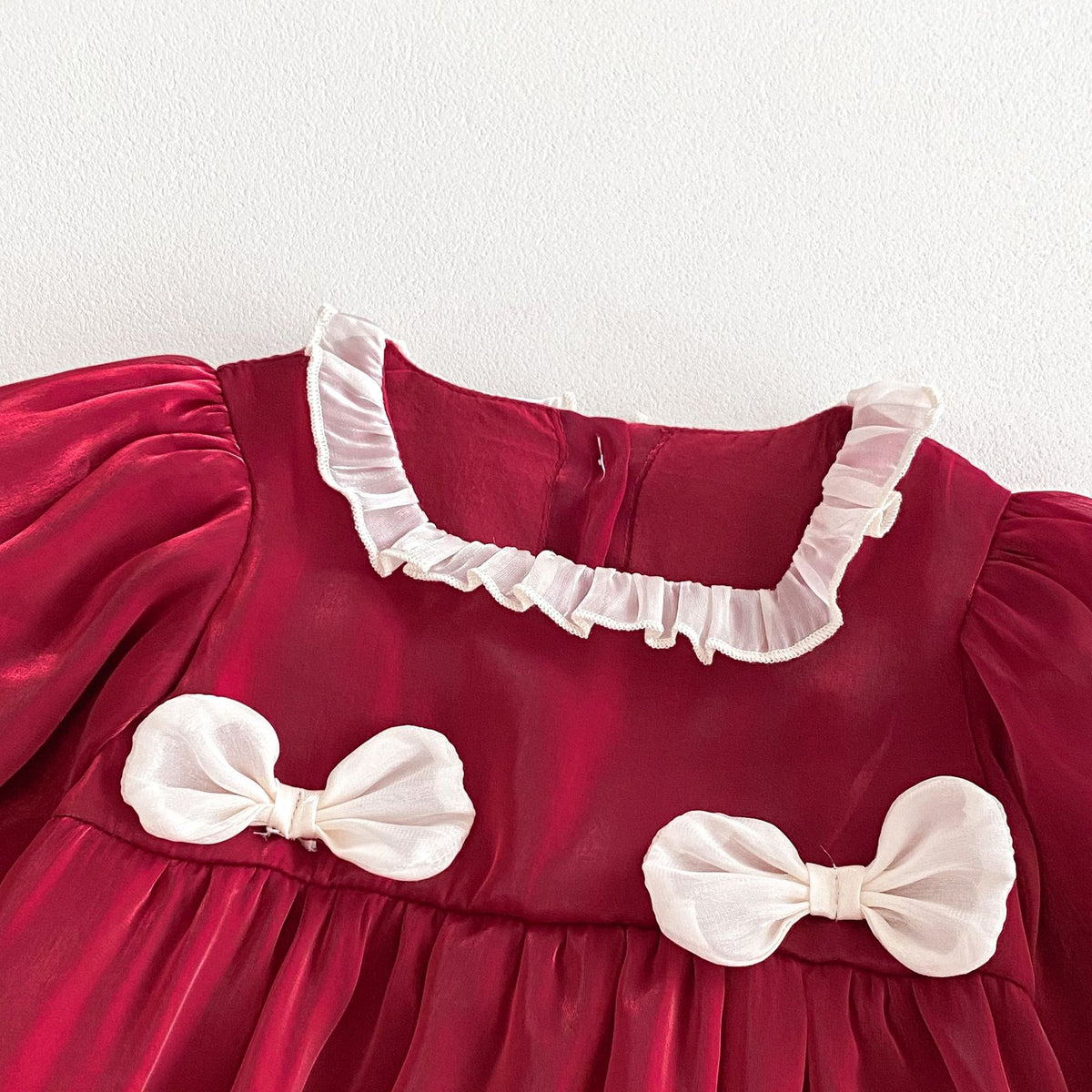 Close-up of lace frill collar and cream bows