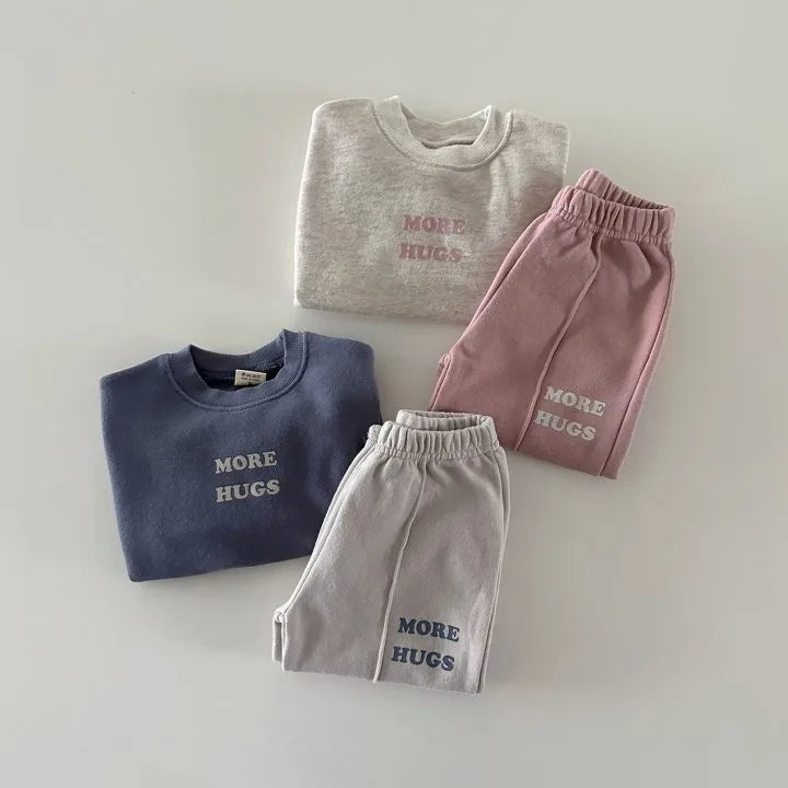 Folded More Hugs sweatshirts and joggers showing embroidery