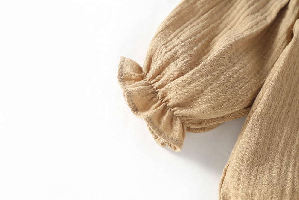 Close-up of frilled cuff on mocha romper sleeve