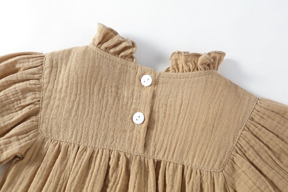 Close-up of ruffle collar and buttons on mocha muslin romper