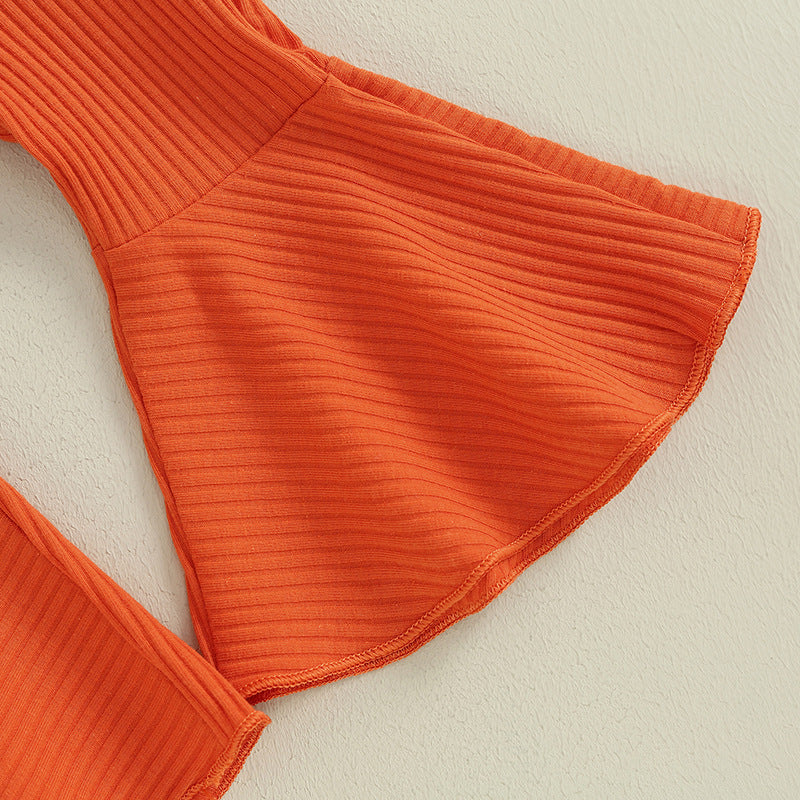 Close-up of orange ribbed flare pants