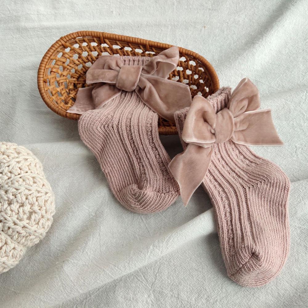 Dusty pink ribbed knit baby socks with velvet bows
