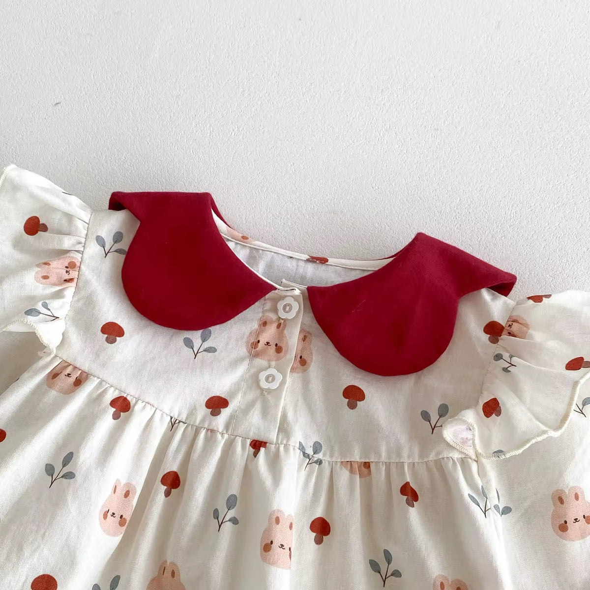 Close-up of red petal collar on floral baby romper