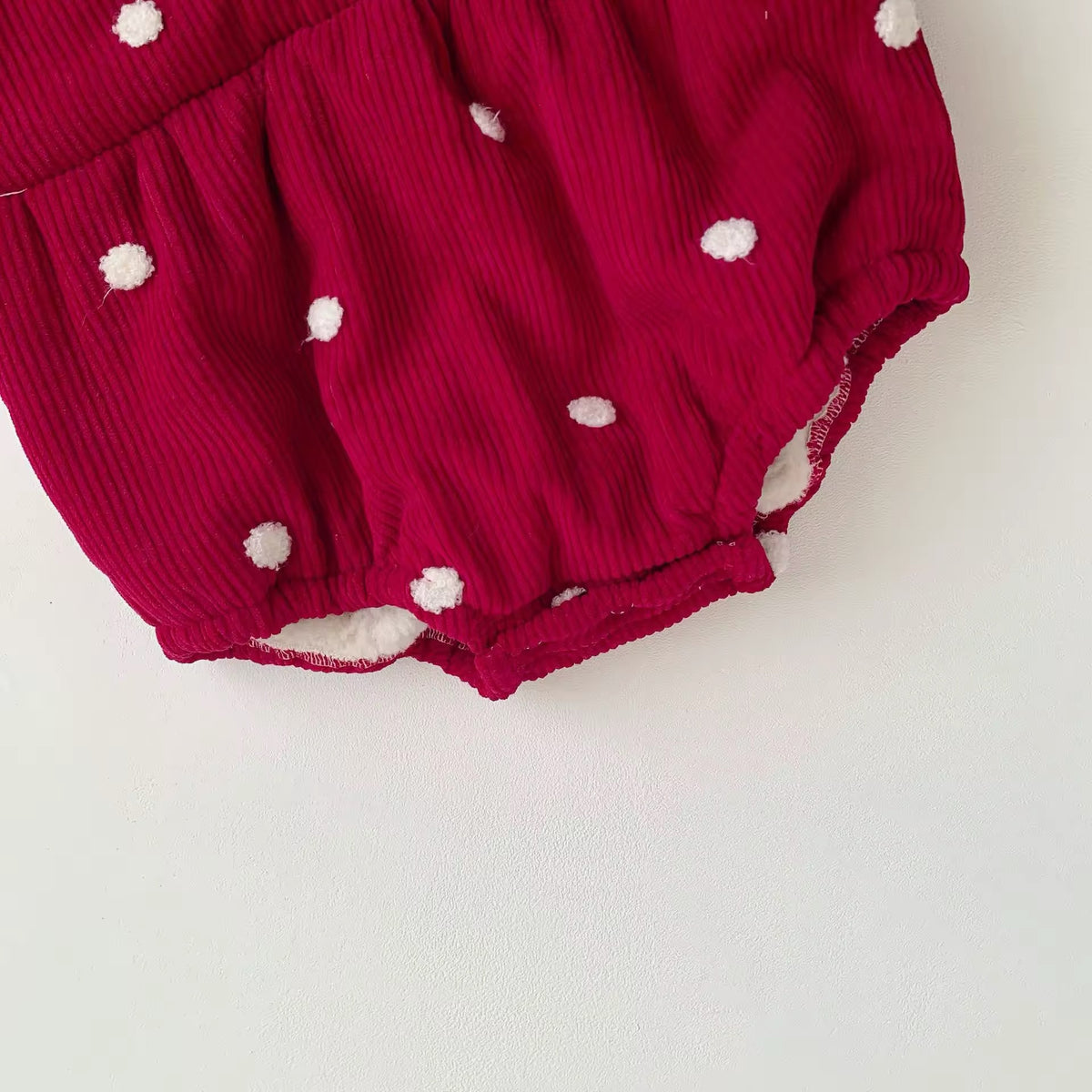 Snap crotch closure on red polka dot baby romper for easy nappy changes