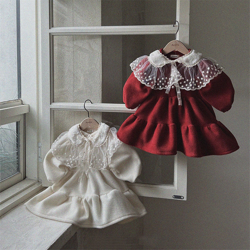 Red princess dress with lace collar and cream dress by a window