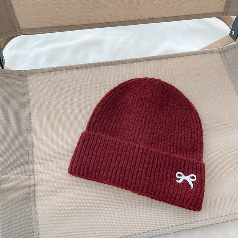 Red ribbed knit beanie with white bow