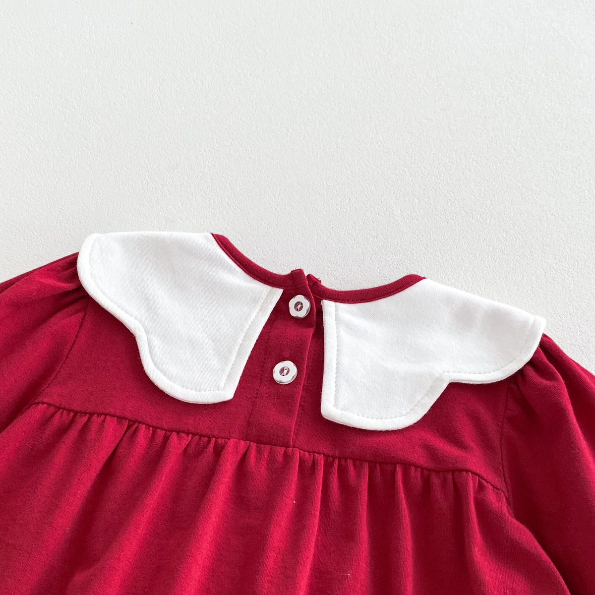 Back view of red romper collar with button closure